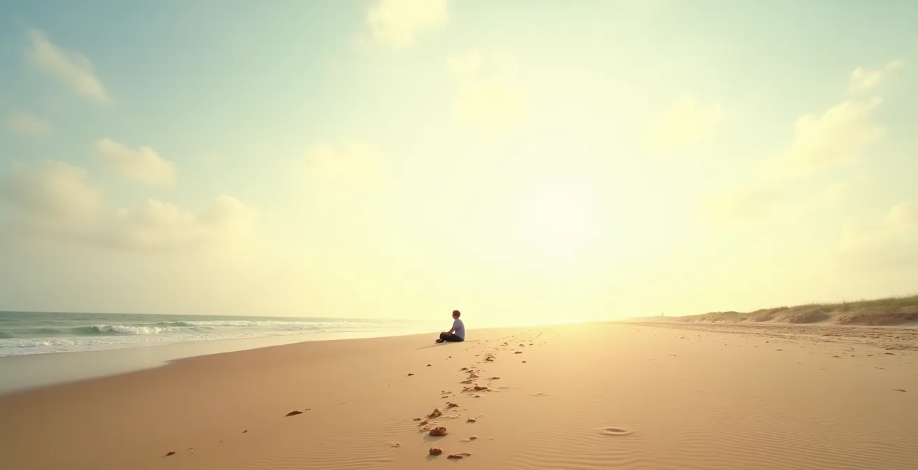 Vista panoramica di una spiaggia tranquilla con una persona seduta lontano che guarda l'orizzonte